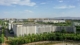 Photograph of a huge data center taking up the majority of a flat landscape dotted with trees in the foreground