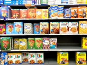 Five shelves of breakfast cereals in a grocery store.