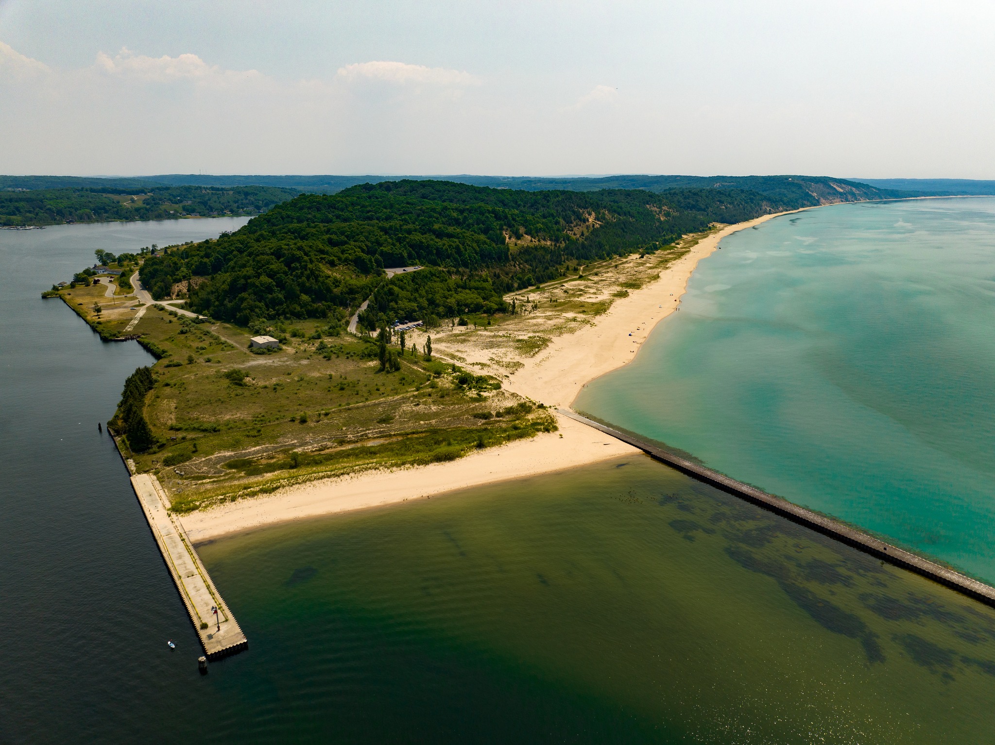 Peninsula jutting into the foreground, with sandy beaches and forest-covered hills.