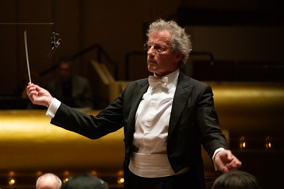 an orchestra conductor waves their wand