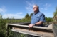 Hoctor stands on boardwalk overlooking wide-open, vegetated space.