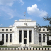 Marriner_S._Eccles_Federal_Reserve_Board_Building The white building with a U.S. flag flying over it and a blue sky in the background