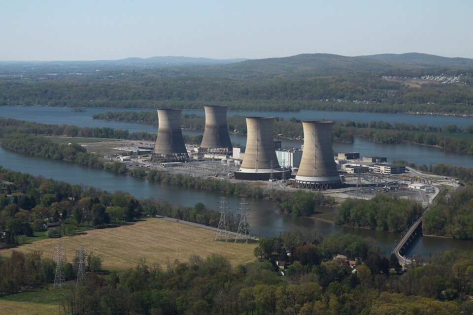 Four giant nuclear reactors sit on a narrow island, with additional islands and mountains in the distance.
