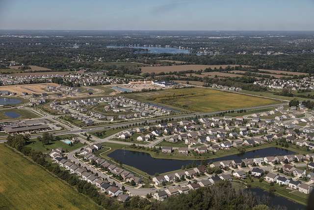 aerial view of sprawling housing divisions, with small plots of farmland interspersed