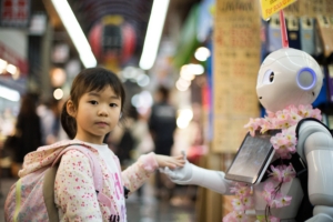 photo of girl holding the hand of a robot