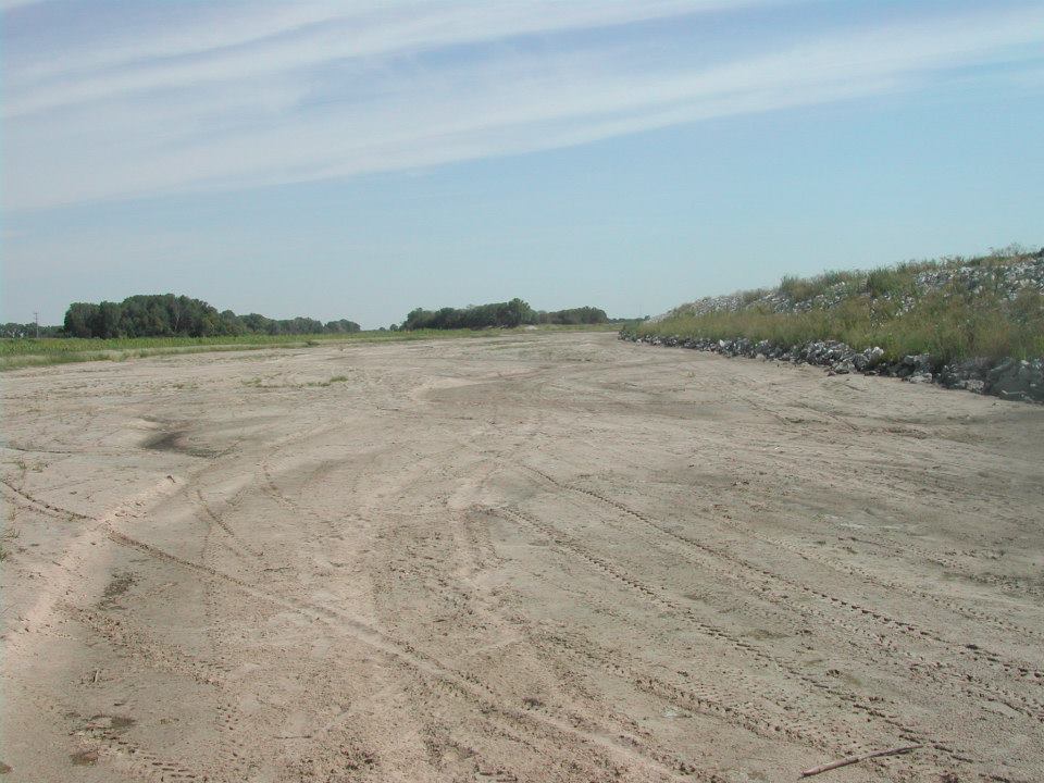 A large dirt corridor crisscrossed with ATV tracks.