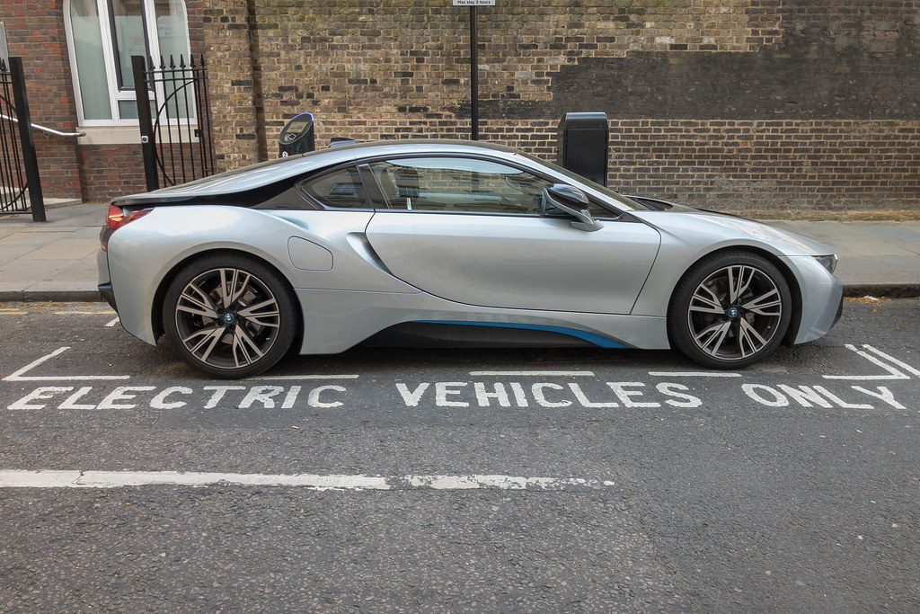 Image of a fancy electric vehicle parked in a spot that reads "Electric Vehicles Only."