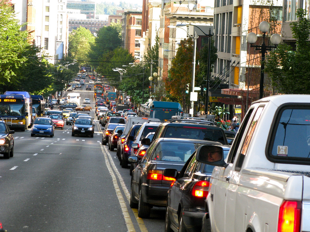 Two lanes of car traffic in a city street.