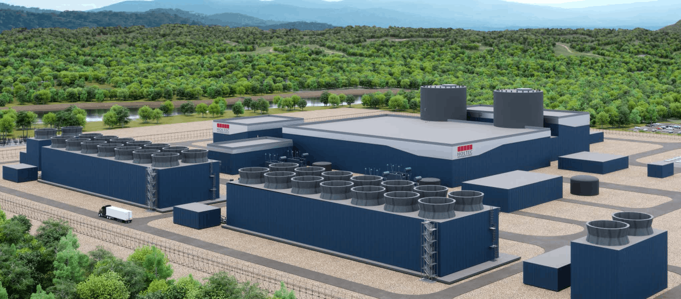 A nuclear-energy facility with trees stretching toward mountains in the distance.
