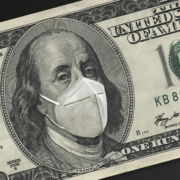 A $100 bill with a medical mask covering Ben Franklin's face.