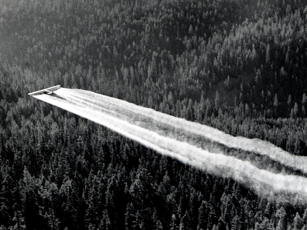 1955 black and white image of fort tri-motor spraying DDT in Oregon.