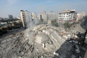 picture of rubble in Gaza, with standing buildings in the background