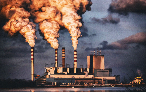 industrial facility with huge plumes of smoke rising from stacks