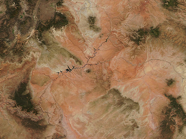 True-color satellite imagery of the drought-stricken Colorado River Basin. The clay-toned landscape washed with white gives a distinctly parched impression.