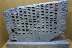 picture of a gray stone block with slots in it