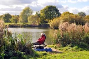 Man resting in a chair beside a pond
