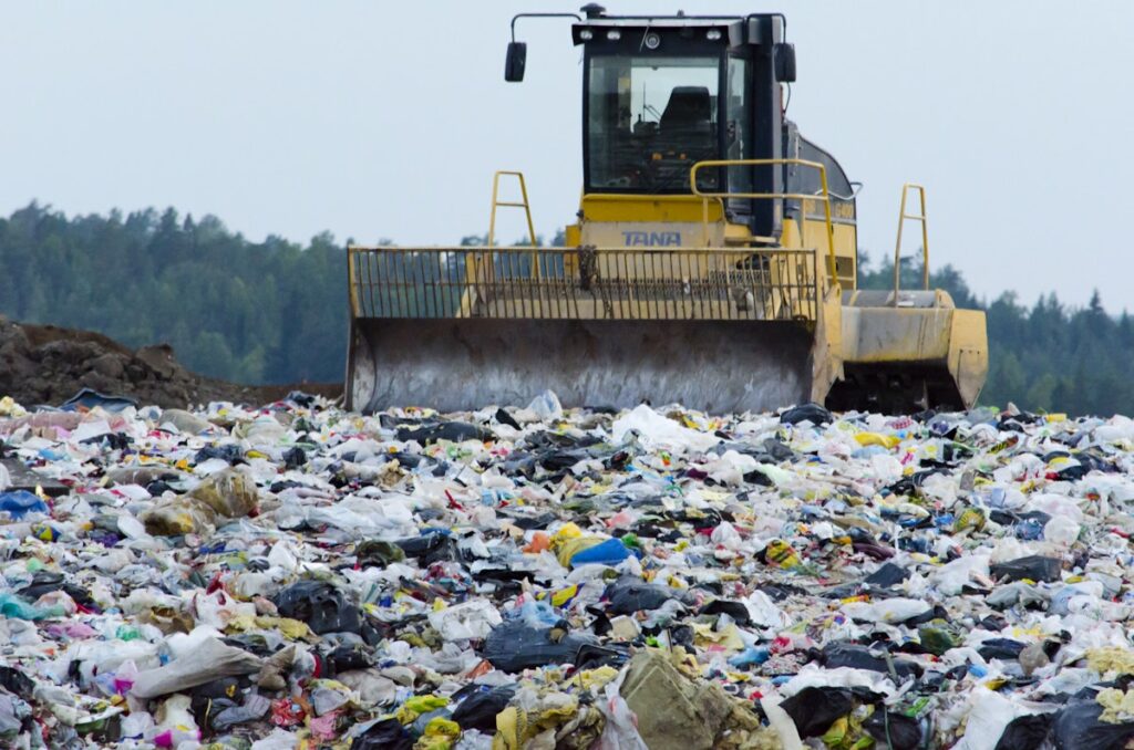 a dump truck amidst a field of trash