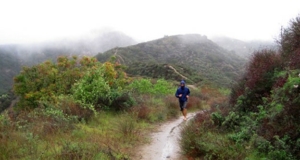 image of man running up a muddy path in the mountains