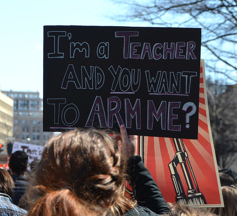 Protest sign reading: I'm a Teacher and you want to arm me?