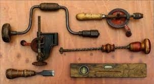 old, worn hand tools displayed on a board