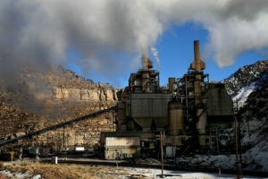 image of a coal-fired power plant in the mountains, with pollution coming out of smoke stacks