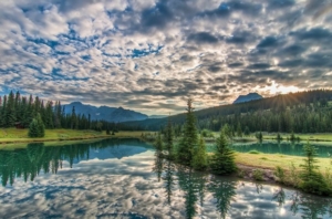 a beautiful landscape showing a river in a mountainous environment, with spackled clouds reflected in the river