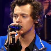 Image of Harry Styles singing into a microphone.