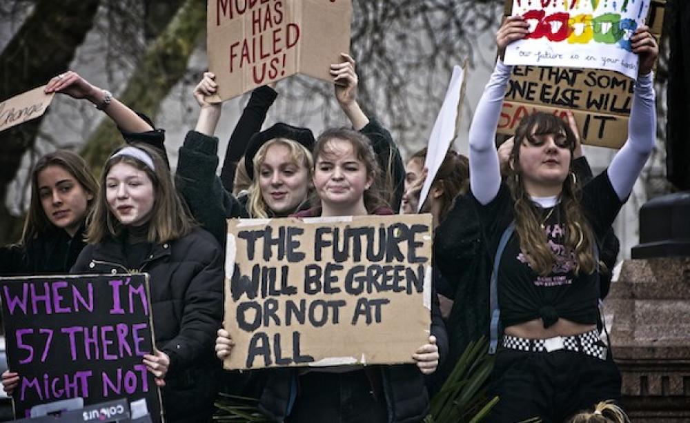 young people hold up handmade signs in protest